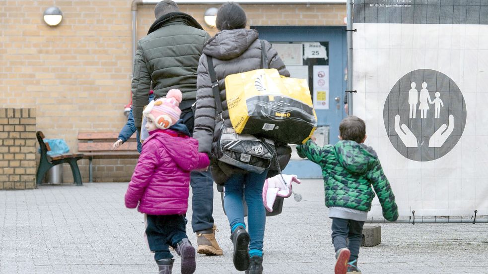 Eine Familie vor einer Flüchtlingsunterkunft in Berlin: Mit der steigenden Zahl an Asylanträgen wachsen auch die Probleme mit der Unterbringung der Menschen in Deutschland. Foto: dpa