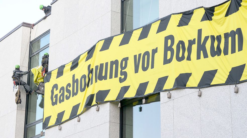 Aktivisten der Umweltschutzorganisation Greenpeace befestigen am frühen Mittwochmorgen Banner an der Fassade des niedersächsischen Landtages. Greenpeace protestiert gegen eine Gasbohrung vor der Nordseeinsel Borkum. Foto: Julian Stratenschulte/dpa