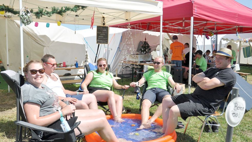 So lässt es sich aushalten: Die Betreuer aus der Gemeinde Großefehn, Laura Gronewold (von links), Renke Janßen, Anna-Lena Gronewold, Marco Fahnster und Stefan Ernst, kühlen sich im kleinen Pool ab. Im Hintergrund sorgen die Weihnachtsdeko und X-Mas-Hits für eine etwas schräge Stimmung bei 27 Grad Celsius. Foto: Kim Hüsing