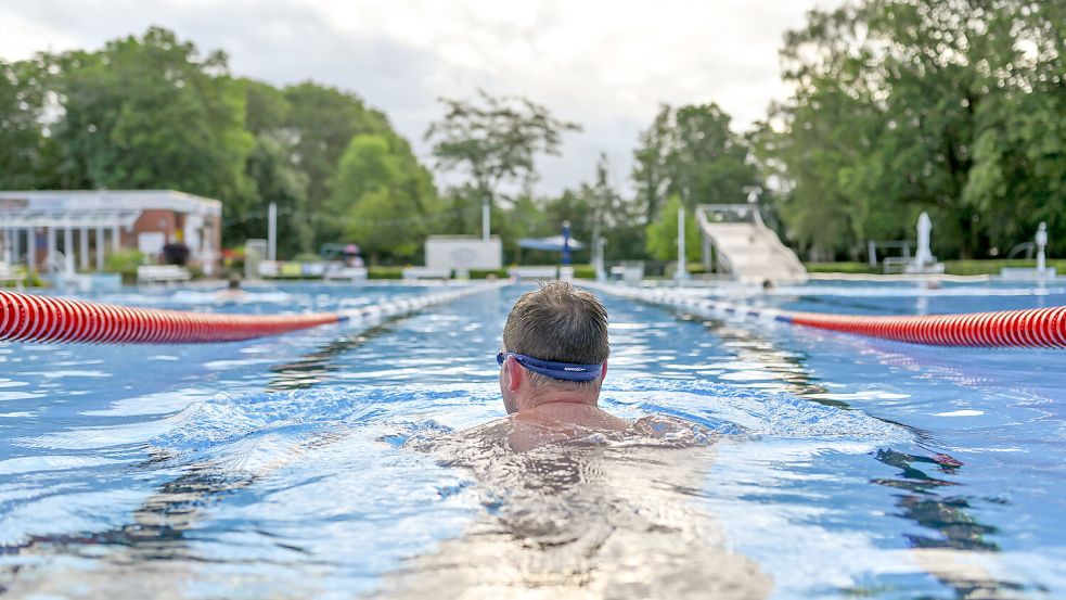 Ein Badegast genießt das morgendliche Schwimmen im Freibad. Foto: DPA