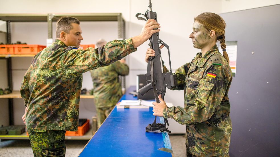 Eine Reservistin erhält in der Waffenkammer ein Sturmgewehr vom Typ G36. Die Frau nimmt mit anderen Teilnehmern an einer Abschlussübung zum Projekt „Ungediente für die Reserve“ teil. Foto: Christoph Schmidt/dpa