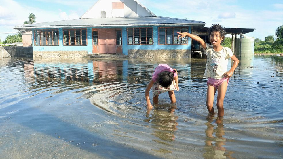 Spielende Kinder auf einem überfluteten Platz in Tuvalu. Der Klimawandel sorgt für eine ungewisse Zukunft auf dem Inselstaat. Foto: dpa/Kyodo