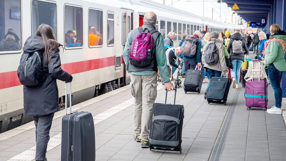 Reisende mit Koffern gehen an einem IC am Bahnhof Norddeich-Mole entlang. Ob und welche Verbindungen zwischen Mittwoch und Montag hier fahren, ist wegen des erneuten Streikaufrufs noch ungewiss. Foto: dpa