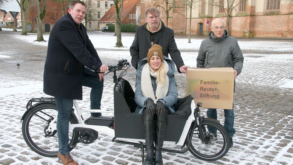 Bürgermeister Florian Eiben (links) , Irma Kracke, Wolfgang Vollert und Harald Reuter präsentieren das neue Lastenrad der Stadt Norden. Foto: Stadt Norden