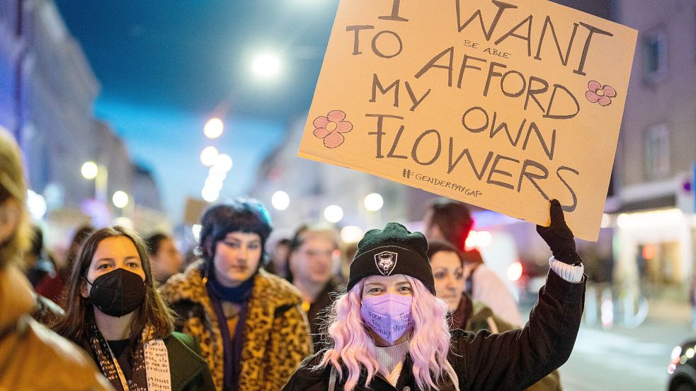 Nicht alle freuen sich über Blumen zum Weltfrauentag: Auf einer Demonstration fordert eine Teilnehmerin stattdessen besseren Lohn. Foto: dpa/APA/Georg Hochmuth