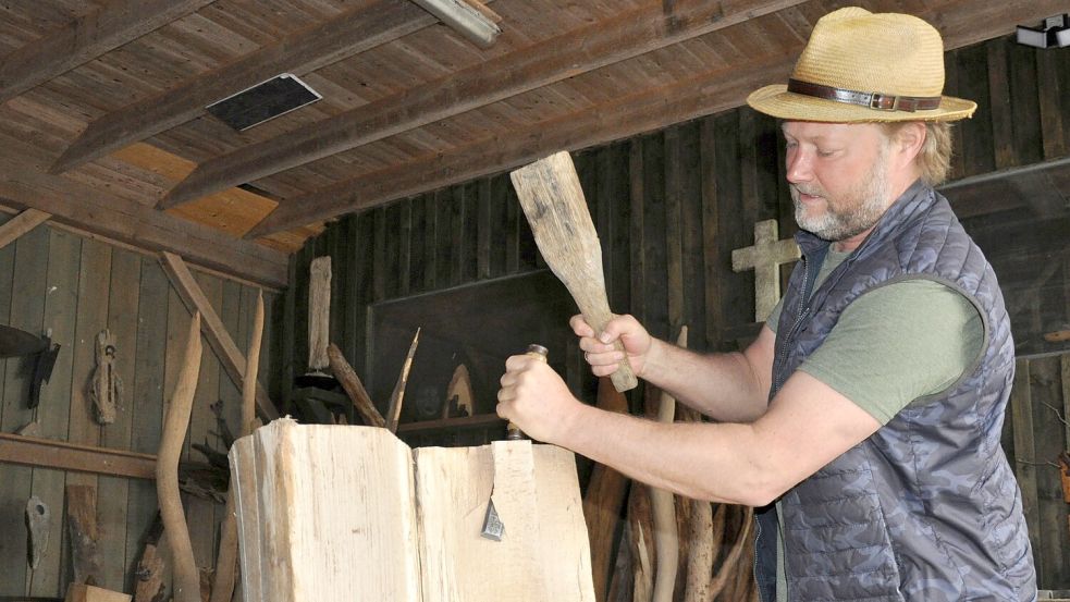 Aus Baumstämmen arbeitet Stefan Doden halbrunde Formen heraus. Diese Rohlinge werden später zu Baumschalen-Reliefs. Foto: Ullrich