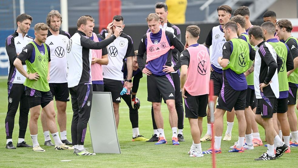 Bundestrainer Julian Nagelsmann nutzt bei einer Besprechung mit den Spielern eine Taktiktafel. Foto: Federico Gambarini/dpa