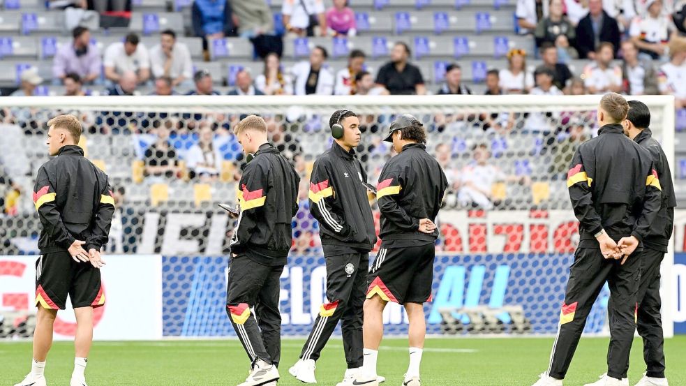 Die deutschen Nationalspieler begutachten vor dem Spiel den Münchner Rasen. Foto: Federico Gambarini/dpa