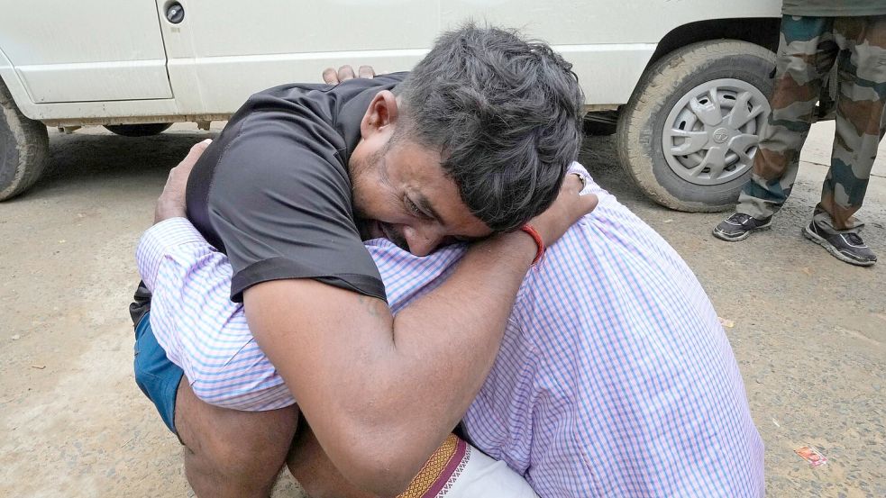 Ein Mann umarmt einen Angehörigen, nachdem seine Schwester Opfer der Massenpanik wurde. Foto: Rajesh Kumar Singh/AP/dpa