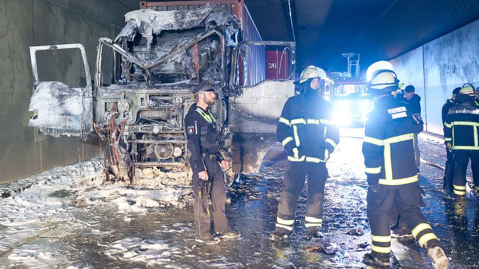 Feuerwehr und Polizei am Wrack des ausgebrannten Lkw im Hamburger Elbtunnel. Foto: dpa