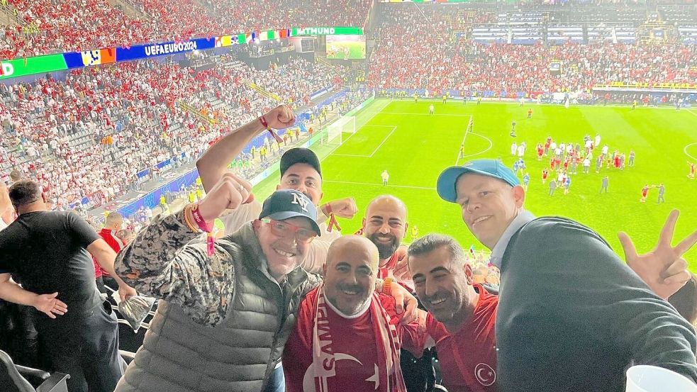Türkische Fans feiern zusammen mit Michael Kortmann (rechts) den 3:1-Sieg gegen Georgien in Dortmund.