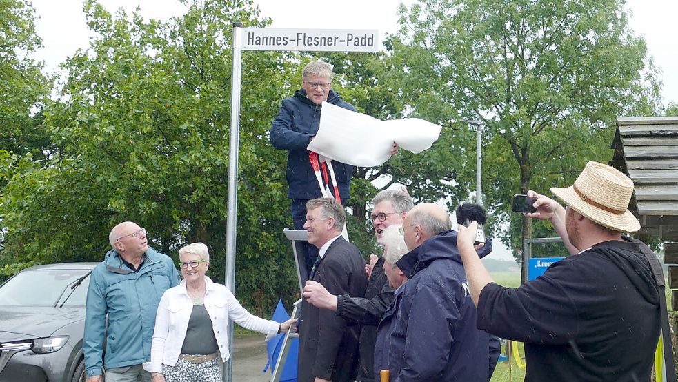 „Wi fragen nich na Wind un Weer“: Ortsbürgermeister Martin Jürgens (Westerende, von links), Antje Harms (Rahe) sowie die Bürgermeister Horst Feddermann (Stadt Aurich) und Arno Ulrichs (Gemeinde Ihlow) bei der Enthüllung des Straßenschildes. Foto: Werner Jürgens