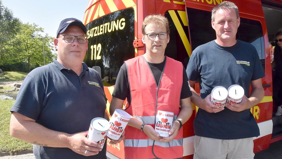 Daniel Weinrank (links) und Brookmerlands stellvertretender Gemeindebrandmeister Christian Lücht (rechts) überreichten Leukin-Botschafter Michael Dirksen-Müller Spendendosen, die die fünf Brookmerlander Ortsfeuerwehren gefüllt hatten. Foto: Thomas Dirks