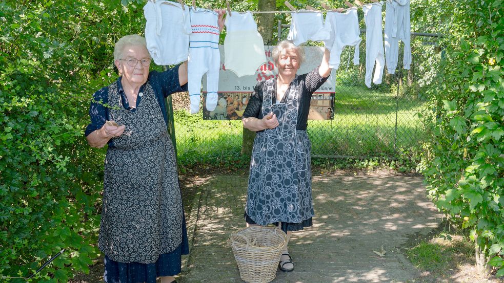 Martha Dieken (von links) und Altje Detmers beim Wäscheaufhängen am historischen Waschtag. Foto: Folkert Bents