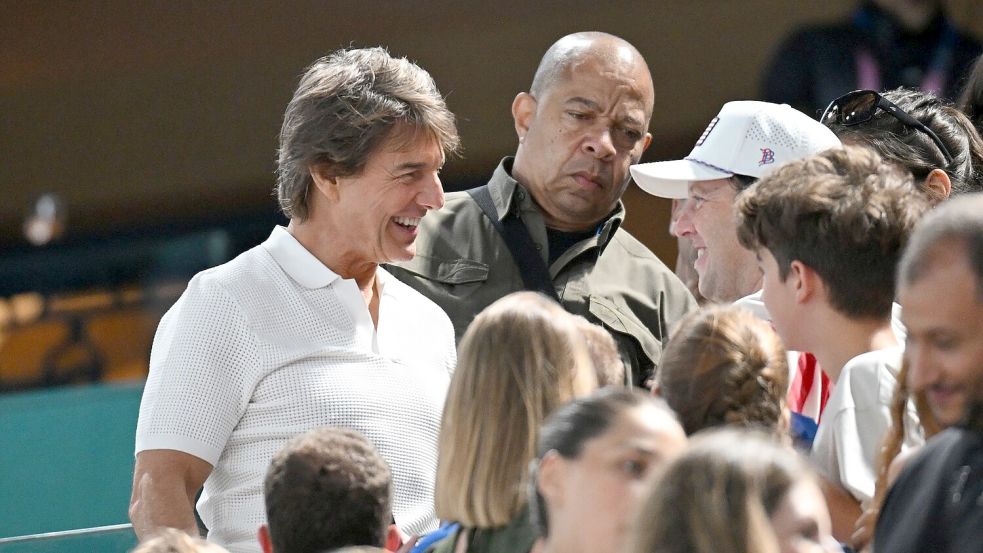 Schauspieler Tom Cruise beim Turnen auf der Tribüne. Foto: Marijan Murat/dpa