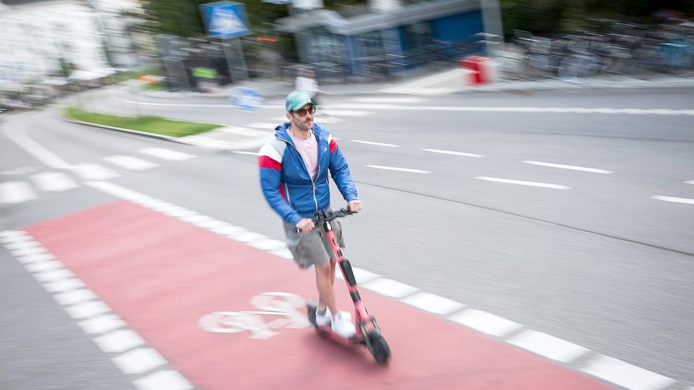 Ein Mann fährt auf einem Radweg in Hamburg mit einem E-Scooter. Foto: Christian Charisius/dpa