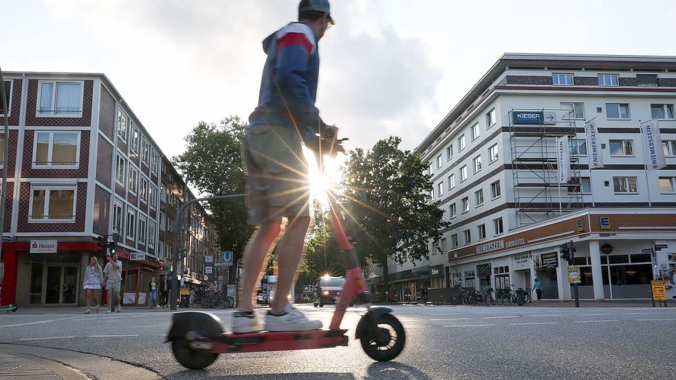 Ein Mann fährt auf einem E-Tretroller. Foto: Christian Charisius/dpa