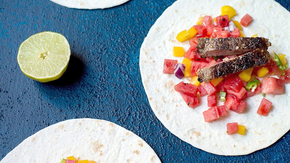 Die Melonensalsa schmeckt feurig-süß, wenn milde Chilis gewählt werden. Auf dem Bild sind die Zutaten bereits auf den Teiglingen verteilt. Nun muss nur noch gerollt werden - und fertig sind leckere Wraps. Foto: Marmelade Kisses/ Obst & Gemüse/1000 gute Gründe