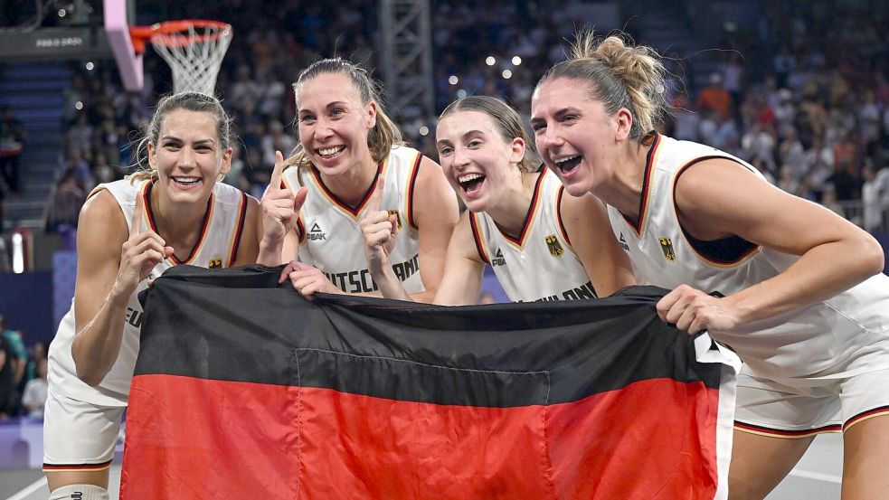 Feiern mit der Fahne: Die 3x3-Basketballerinnen. Foto: Sina Schuldt/dpa