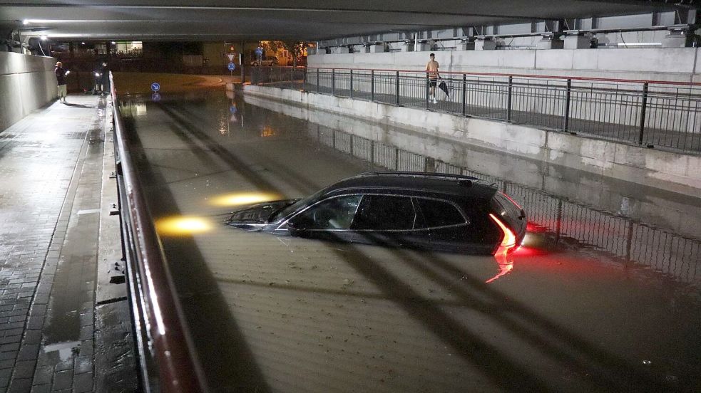 Nach einem schweren Gewitter steht ein Auto in Bruchsal bis zur Motorhaube im Wasser. Foto: René Priebe/dpa