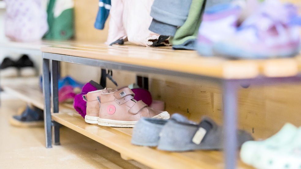 Schuhe stehen in einer Garderobe in einer Kita. Foto: DPA