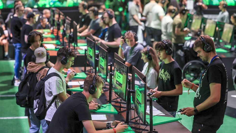 Computerspieler probieren bei der Gamescom Spiele aus. Foto: Oliver Berg/dpa