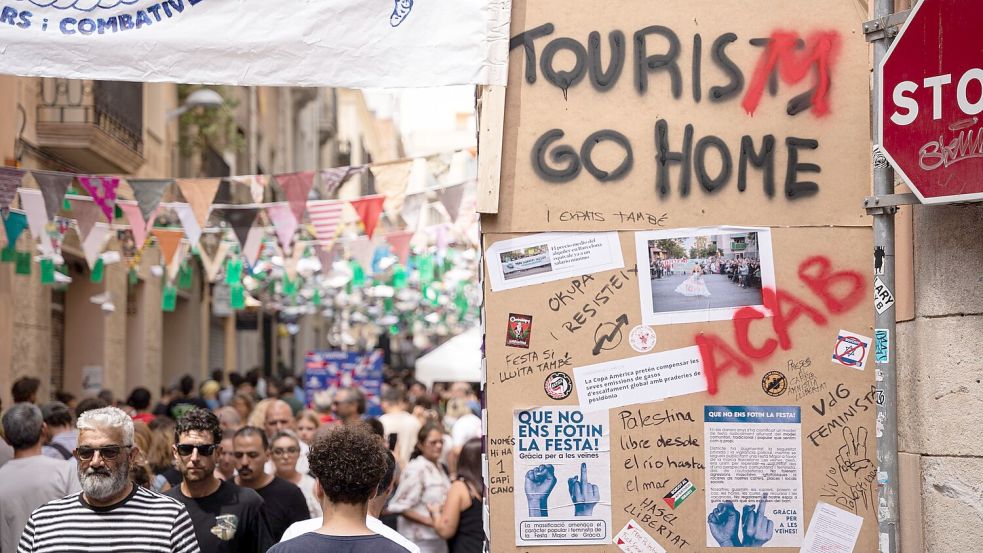 „Tourists go home“ beziehungsweise „Tourism go home“ steht an einer Wand in Barcelona (August 2024). Foto: Marc Asensio Clupes/ZUMA Press Wire/dpa