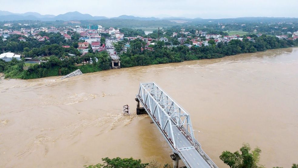 Ein Teil der Brücke stand noch, der Rest verschwand in kurzer Zeit in den Fluten. Foto: Bui Van Lanh/VNA/AP/dpa