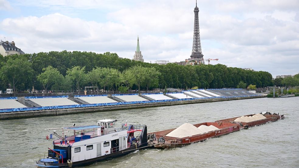 Keine Filmszene, sondern ein Foto aus dem Sommer während Olympia. Ein Schiff passiert Tribünen, im Hintergrund ist der Eiffelturm zu sehen. Im Netflix-Hit „Im Wasser der Seine“ treibt dagegen ein Hai sein Unwesen im Pariser Gewässer. (Archivbild) Foto: Sina Schuldt/dpa