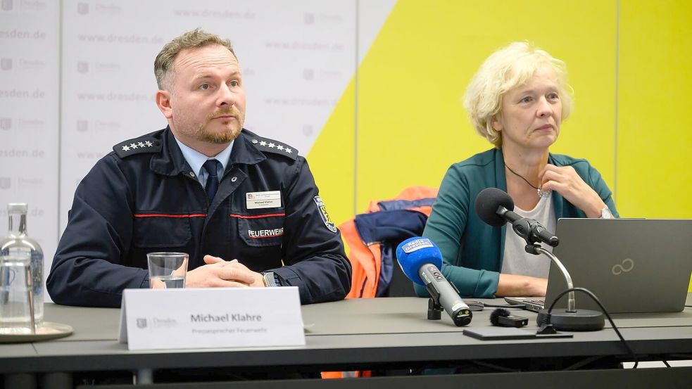 Michael Klahre, Sprecher der Feuerwehr Dresden, und Simone Prüfer, Chefin des Straßen- und Tiefbauamtes in Dresden, berichten vom Zeitdruck bei den Abrissarbeiten am eingestürzten Teil der Carolabrücke. Foto: Robert Michael/dpa