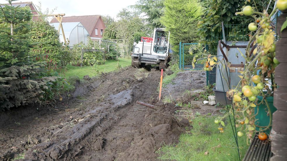 Der Bagger quetscht sich zwischen den Gärten hindurch, um den Graben auszuheben. Foto: Romuald Banik