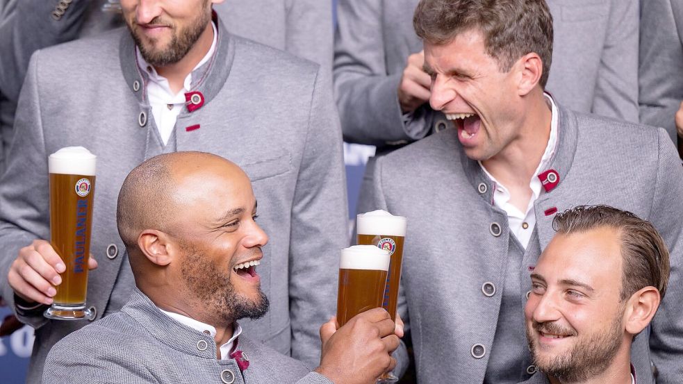 Anstoßen auf den nächsten Sieg? Vincent Kompany (vl) und Thomas Müller (hr) prosten sich zu. Foto: Lennart Preiss/dpa