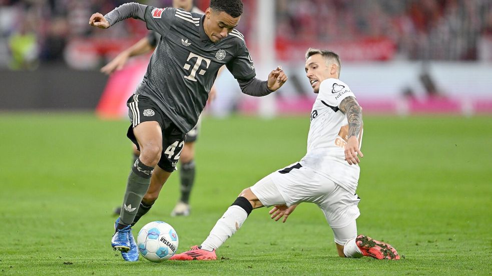 Bayern-Profi Jamal Musiala (links) dribbelt an Leverkusens Alejandro Grimaldo vorbei. Foto: Sven Hoppe/dpa