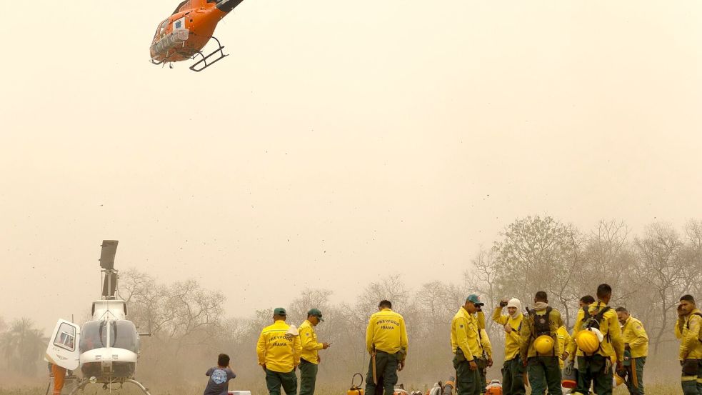 Indigene Feuerwehrleute warten auf ihren nächsten Einsatz. Foto: Diego Cardoso/dpa