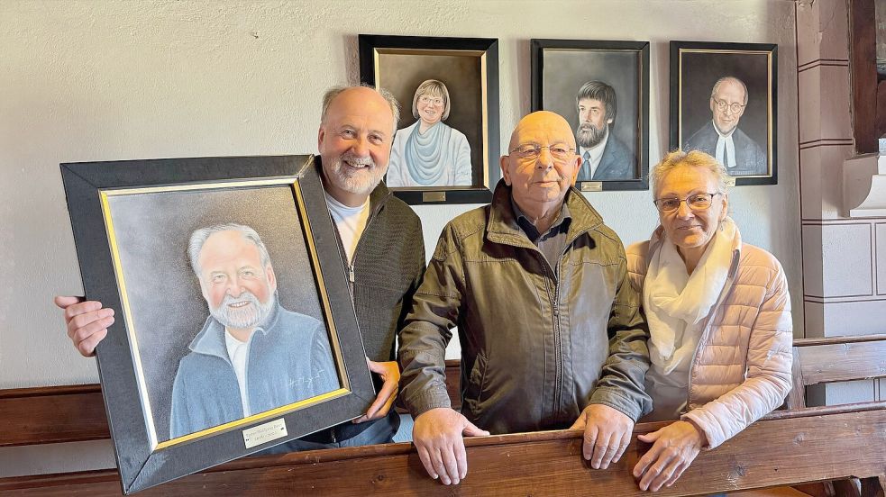 Pastor Wolfgang Beier (von links), Eilert und Harmine Meyer vor einem Teil der neuen Münkeboer Pastoren-Galerie. Foto: Holger Janssen