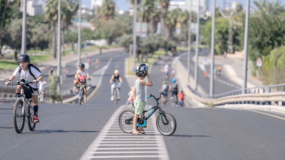 Menschen in Israel sind mit ihren Fahrrädern auf einer leeren Straße am Feiertag Jom Kippur unterwegs (Foto aktuell). Foto: Ilia Yefimovich/dpa