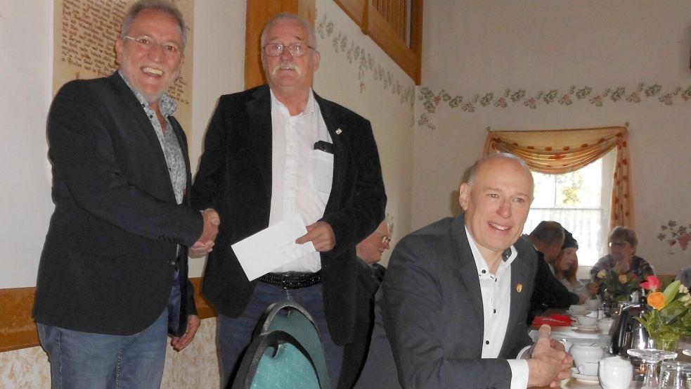 Georg Marken (Mitte), Vorsitzender des Ortsverbandes Spetzerfehn im Sozialverband Deutschland, freute sich über ein Geschenk von Ortsbürgermeister Manfred Janssen (links). Rechts im Bild Bürgermeister Erwin Adams, der auch ein Präsent zum 75-jährigen Bestehen beisteuerte. Foto: Hinrich Trauernicht