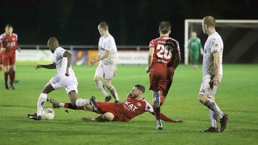 Die Wiesmoorer (rote Trikots) kämpften leidenschaftlich um jeden Ball. In dieser Szene grätschte der Germanen Kapitän Jürgen Zimmermann nach der weißen Kugel. Zimmermann markierte den Siegtreffer zum 1:0 gegen Aurich. Foto: Wilfried Gronewold