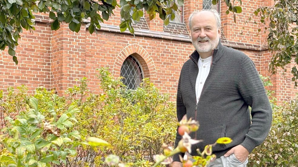 Wolfgang Beier inmitten des grünen Gartens vor der Münkeboer Kirche. Foto: Holger Janssen