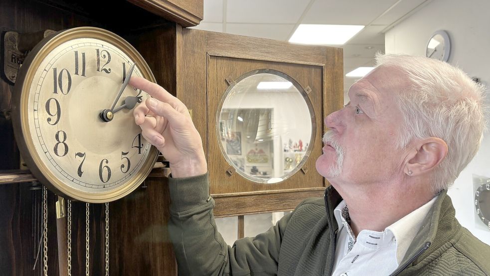 Werner Kaluza stellt in seinem Geschäft in Ostgroßefehn die Zeiger einer 100 Jahre alten Standuhr wieder richtig ein. Fotos: Christin Wetzel