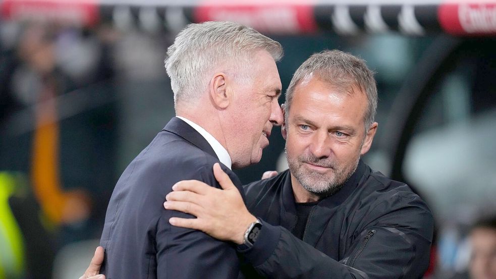 Real-Coach Carlo Ancelotti (l) begrüßt Hansi Flick im Bernabéu. Der Gäste-Trainer freut sich am Ende über einen spektakulären Sieg. Foto: Manu Fernandez/AP