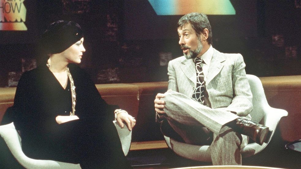 Moderator Dietmar Schönherr bemüht sich redlich in der Talkshow „Je später der Abend“, Romy Schneider zum Reden zu bringen. (Archivbild) Foto: Horst Ossinger/ dpa