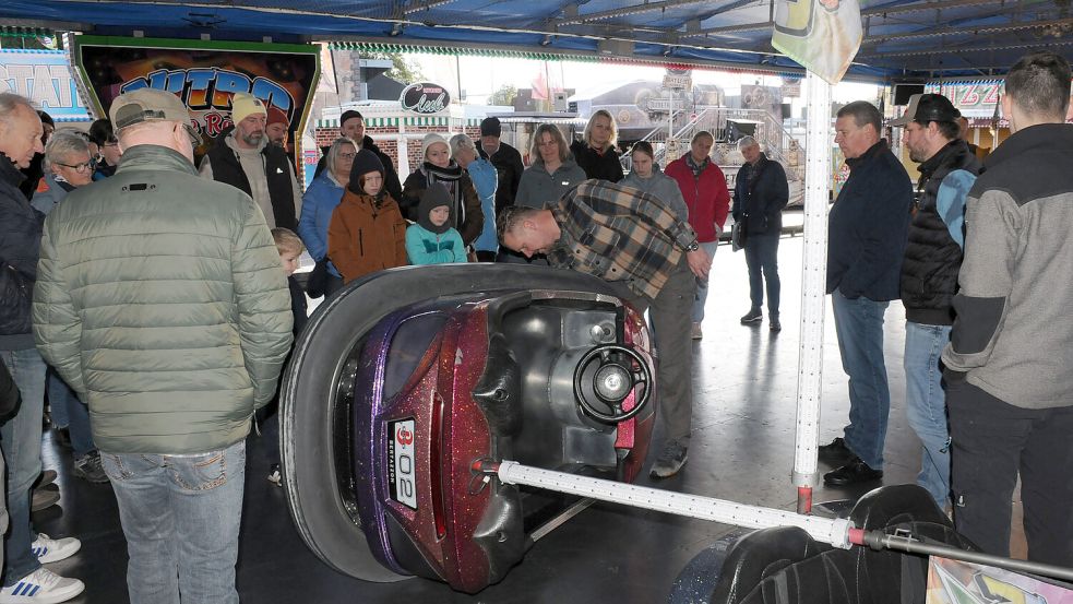 Ungewohnter Anblick: Schaustellerchef Timo von Halle zeigte den 40 ON-Tour-Teilnehmern am Sonntagvormittag auf dem Rundgang über den Herbstmarkt, wie ein Autoscooter-Wagen funktioniert. Die Leserinnen und Leser hatten ihren Spaß an dem informativen Spaziergang über das Volksfest. Foto: Udo Hippen