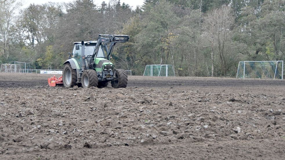 Der Traktor eines Lohnunternehmers zieht seine Bahnen über den Sportplatz in Upgant-Schott. Foto: Thomas Dirks