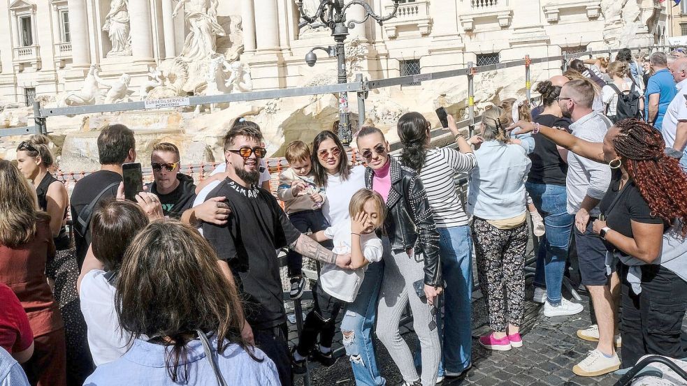 Touristen am Trevi-Brunnen - Massentourismus ist ein großes Problem in Italien. (Archivbild) Foto: Mauro Scrobogna/LaPresse/AP/dpa