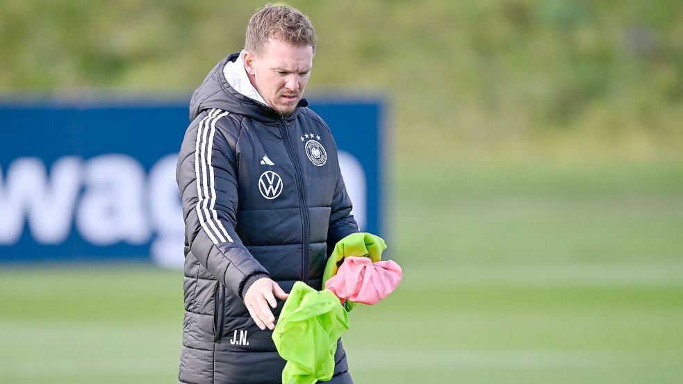 Bundestrainer Nagelsmann sortiert die Leibchen für das Training. Foto: Uwe Anspach/dpa