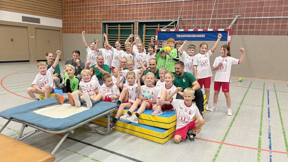 Die Fäuste zur Hallendecke gereckt, lassen die Jungen und Mädchen des Holtroper Handballnachwuchses zusammen mit ihrem Trainerteam ihren Schlachtruf von den Holtroper Füchsen erklingen. Foto: Wolf-Rüdiger Saathoff