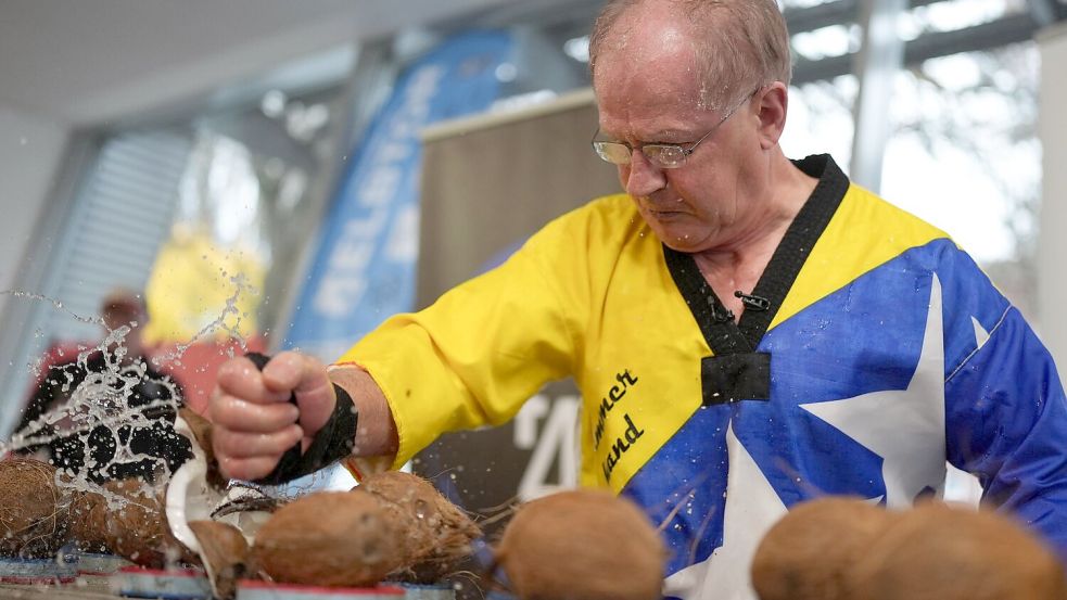 Muhamed schaffte es, 76 Kokosnüsse in 30 Sekunden mit der Hand zu zerschlagen. Foto: Marcus Brandt/dpa