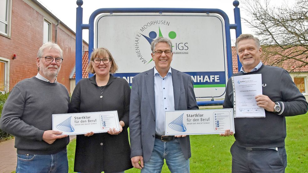 Jury-Vorsitzender Frank Happe (rechts) und sein Jury-Kollege Reinhold Harms (links) überreichten das Gütesiegel an den Leiter der IGS Marienhafe-Moorhusen, Kai Hoop (Zweiter von rechts) und dessen Kollegin Maraike Osterkamp, Hauptverantwortliche für die Berufsorientierung der IGS. Foto: Thomas Dirks