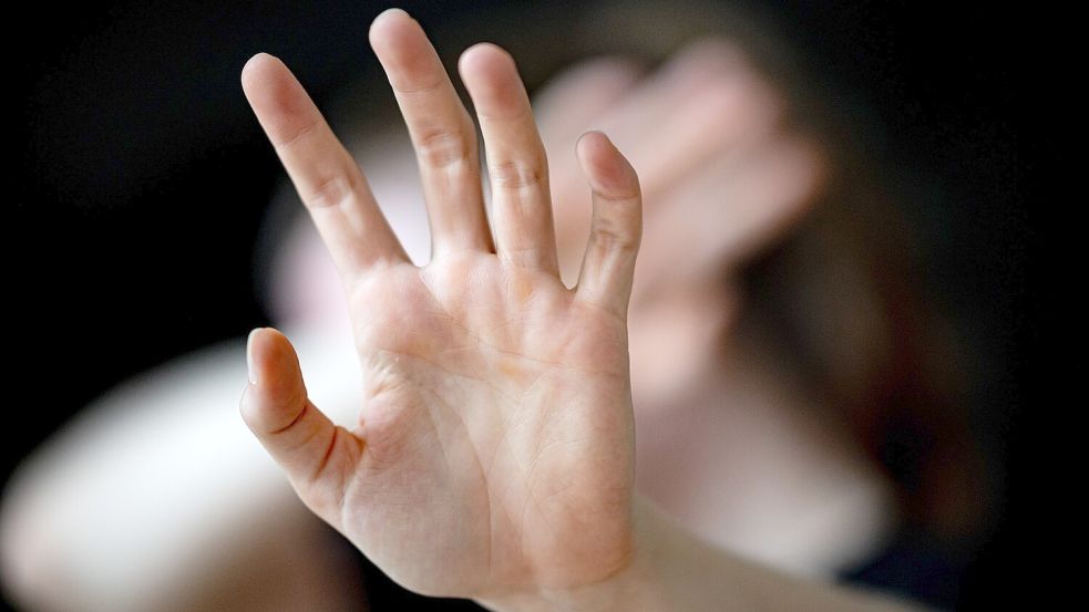 Eine Frau hält sich in diesem Symbolbild schützend die Hand vors Gesicht. Foto: Fabian Sommer/DPA